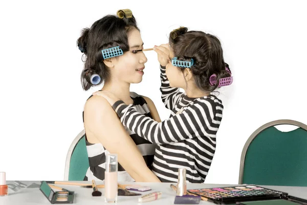 Cute girl applying a mascara to her mother — Stock Photo, Image