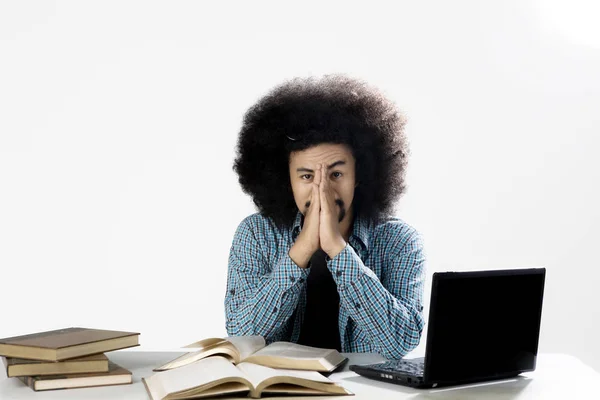 Deprimido estudante masculino com laptop e livros — Fotografia de Stock