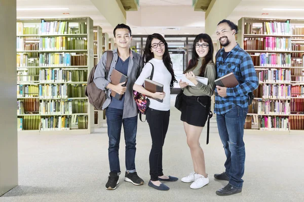 Diversidad estudiantes universitarios de pie en la biblioteca —  Fotos de Stock