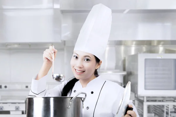 Cuoca che cucina con pentola in cucina — Foto Stock