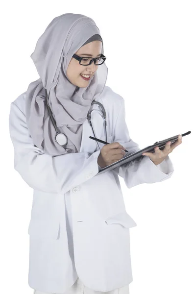 Doctora escribiendo en un portapapeles — Foto de Stock