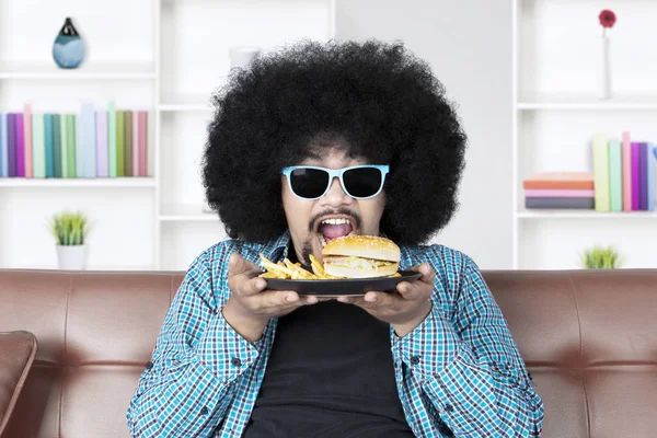 Éhes Afro ember eszik sajtburger — Stock Fotó