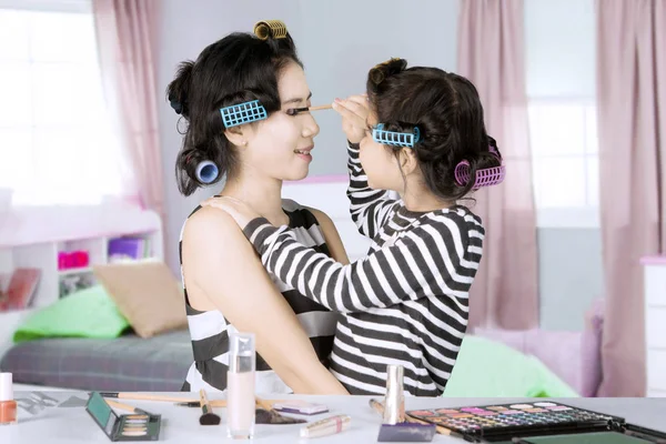 Küçük kız ve annesi maskara ile oynamak