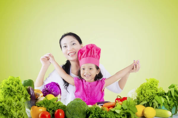 Маленька дівчинка і мати з овочами — стокове фото