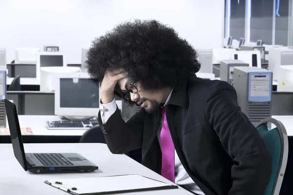 Empresario masculino siente dolor de cabeza en el lugar de trabajo —  Fotos de Stock