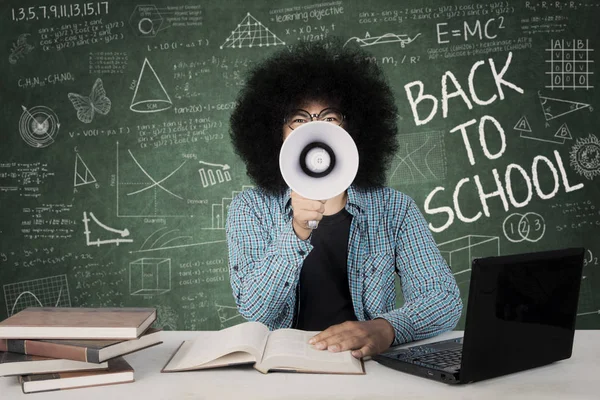 Male student using megaphone in the classroom — Stock Photo, Image