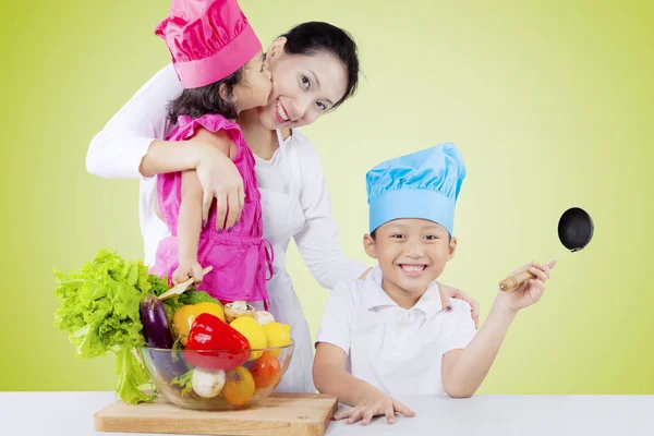 Mãe e crianças cozinham legumes — Fotografia de Stock