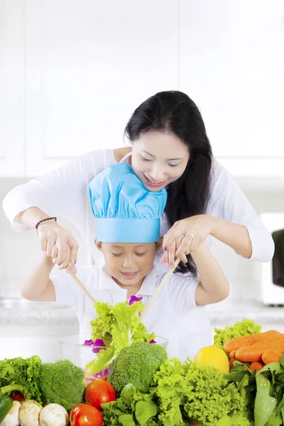 Anne ve oğlu öğle yemeği için salata yapmak — Stok fotoğraf