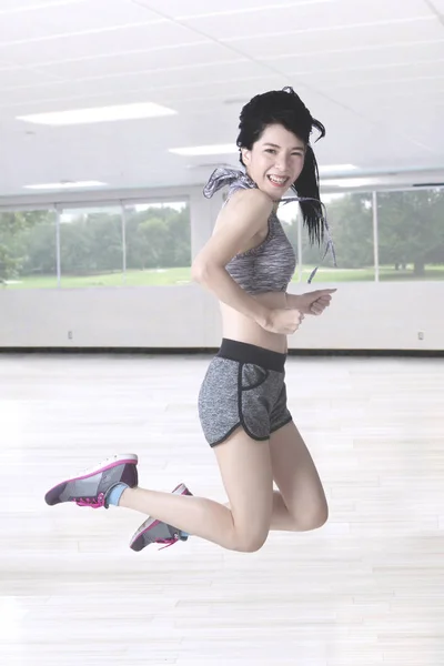 Mulher magro pulando no centro de fitness — Fotografia de Stock