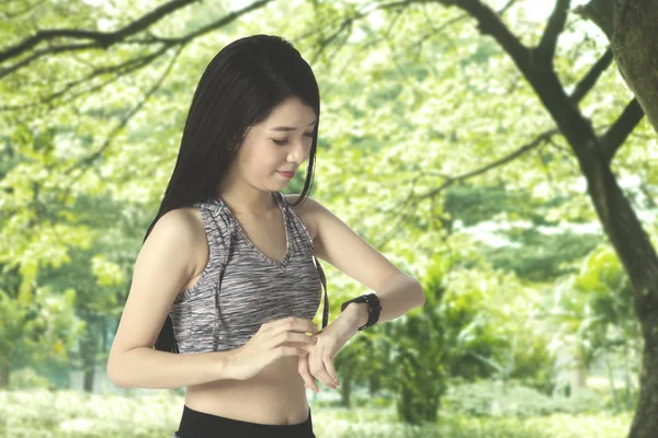 İnce kadın smartwatch Park'ta üzerinde seyir