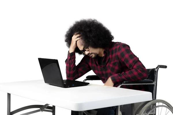 Stressful man using laptop on a wheelchair — Stock Photo, Image