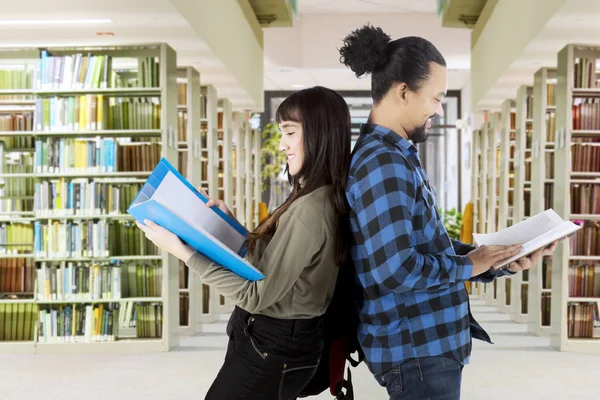 Två multietniskt studenter står i biblioteket — Stockfoto