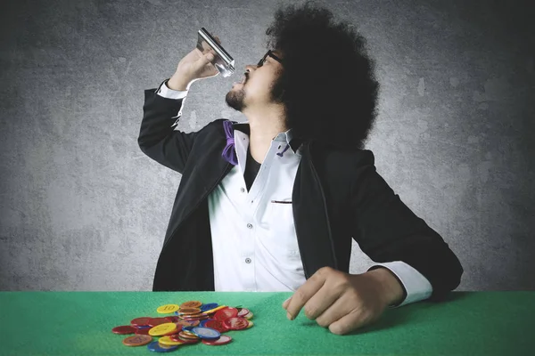 Young man drinking whiskey and playing poker — Stock Photo, Image