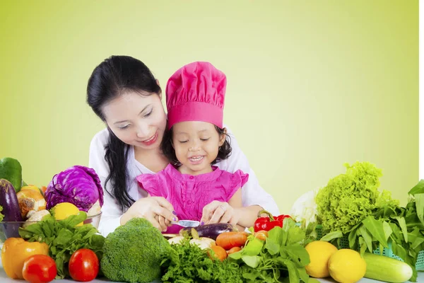 Fiatal nő tanítja a lányát, hogy főzni — Stock Fotó