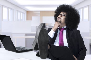 Afro işadamı işyerinde dalgın görünüyor