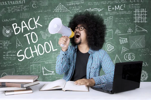 Afro college student with megaphone and scribbles — Stock Photo, Image
