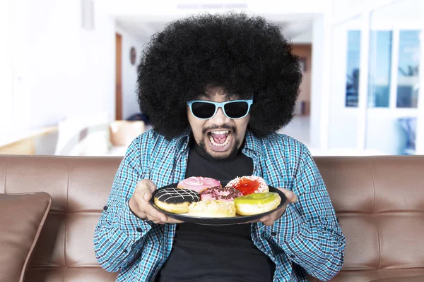 Afro man holds tasty donuts — Stock Photo, Image