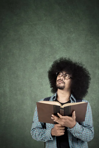 Afro hombre pensando solución con libro — Foto de Stock