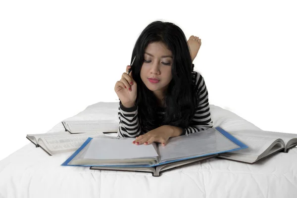Aantrekkelijke vrouwelijke student studeert op bed — Stockfoto