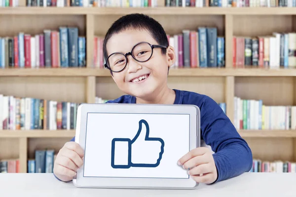 Cheerful student shows thumb up icon in library — Stock Photo, Image