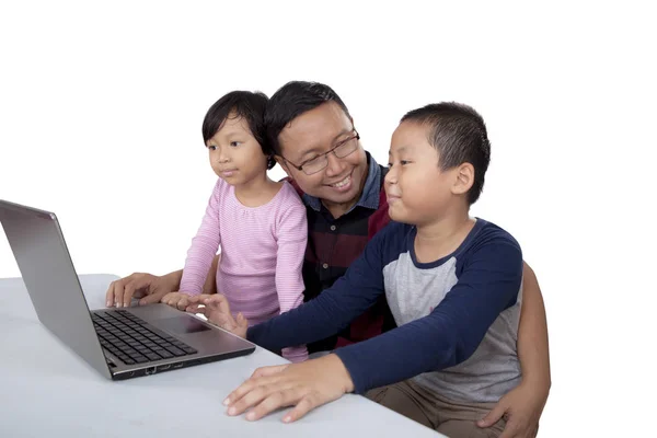 Enfants et papa utilisent un ordinateur portable sur la table — Photo