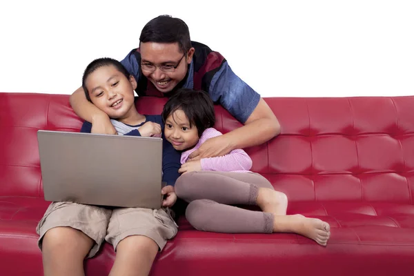 Папа и дети используют ноутбук на диване — стоковое фото