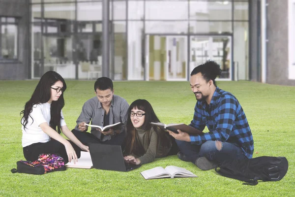 Diverse college students studying in the park