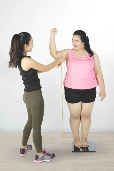 Instructor que mide bíceps de mujer gorda — Foto de Stock