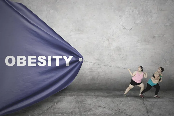 Obese women pulling Obesity text — Stock Photo, Image