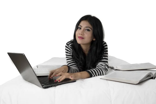 Chica bonita estudiando con portátil en la cama —  Fotos de Stock