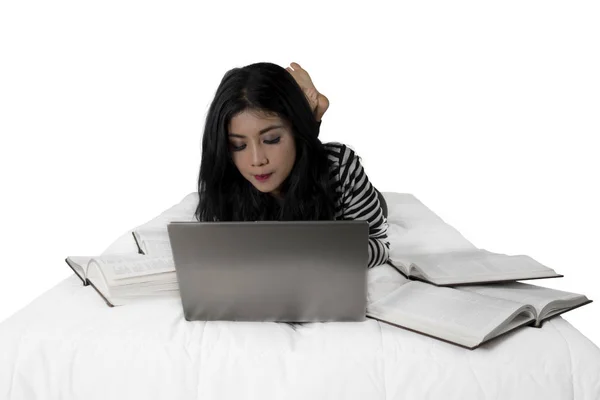Mooie student leert met laptop op bed — Stockfoto