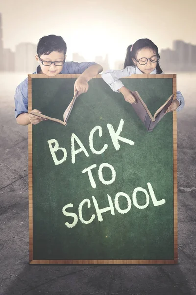 Primary students behind text of back to school — Stock Photo, Image