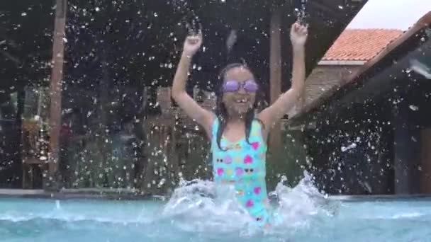 Criança de câmera lenta salpicando água na piscina — Vídeo de Stock