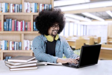 Bir dizüstü bilgisayar ve kitap Afro öğrenci