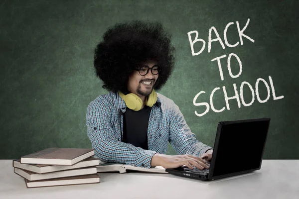 Estudante afro digitando em um laptop — Fotografia de Stock