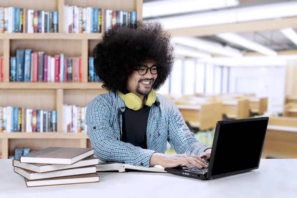 Bir dizüstü bilgisayar ve kitap Afro öğrenci