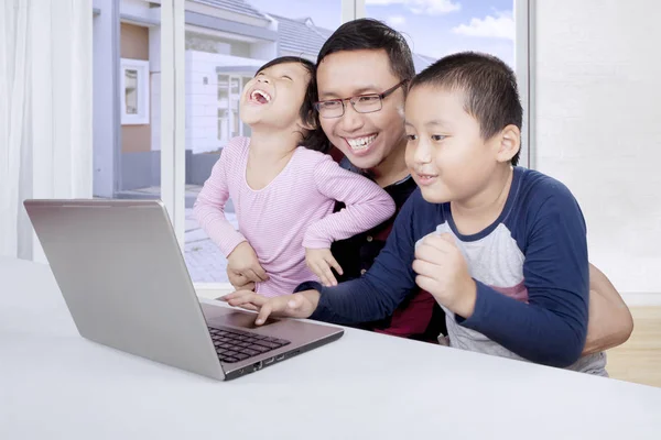 亚洲的父亲和他的孩子们使用一台笔记本电脑 — 图库照片