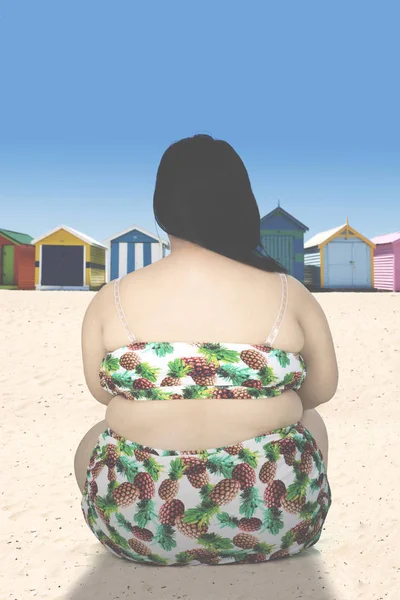 Achterkant van zwaarlijvige vrouw aan kust — Stockfoto