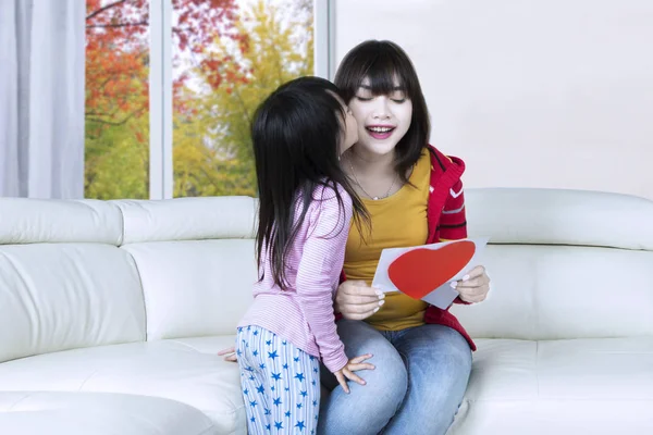 Bambino baciare la sua mamma sul divano — Foto Stock