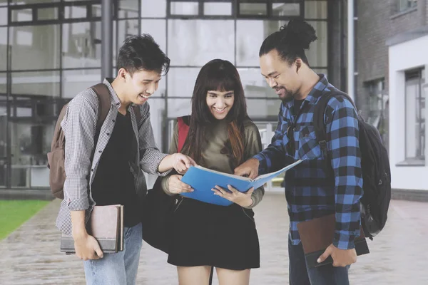 Högskolestudenter som diskuterar en tilldelning — Stockfoto