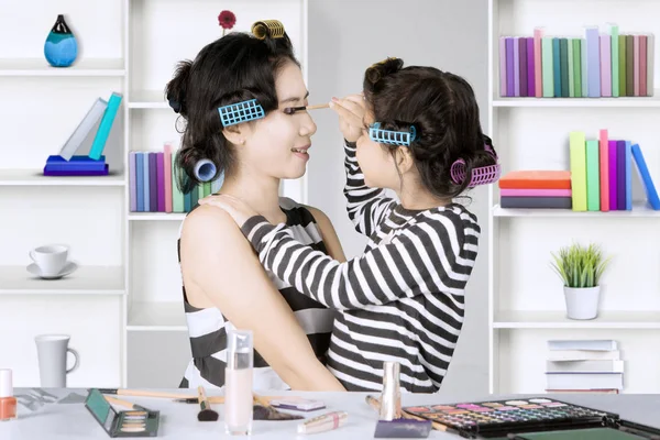 Sevimli kız ve annesi maskara kullanarak