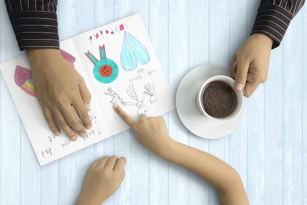 Papá y el niño manos con tarjeta de felicitación — Foto de Stock