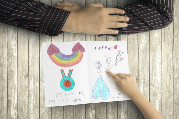 Padre e hijo manos con tarjeta de felicitación — Foto de Stock