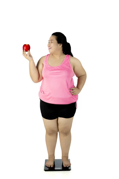 Mujer gorda feliz con escamas y manzana — Foto de Stock