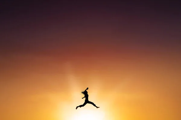 Joyful woman leaps at dusk time — Stock Photo, Image