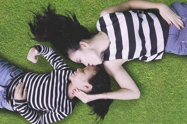 어린 소녀와 엄마는 풀밭에 누워 — 스톡 사진