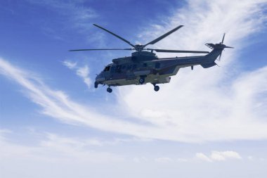 Askeri helikopter mavi gökyüzünde uçan