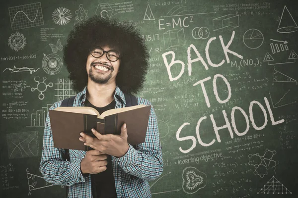 Joven estudiante sostiene libro con garabato — Foto de Stock