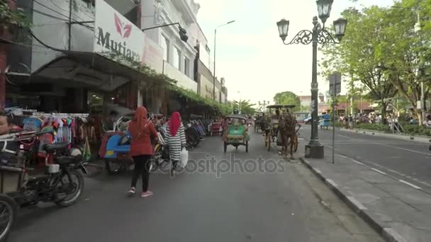 Vista de la calle Malioboro con carro de caballos y rickshaws — Vídeos de Stock