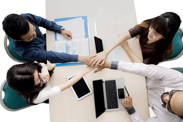 Equipe de negócios juntando as mãos acima da mesa — Fotografia de Stock